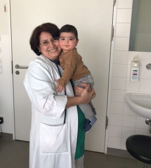 Carmen Herlinghaus mit einem Migrantenkind aus dem Irak, das sehr schwer erkrankt war. Das Foto entstand kurz vor seiner Entlassung aus dem Krankenhaus (2018)